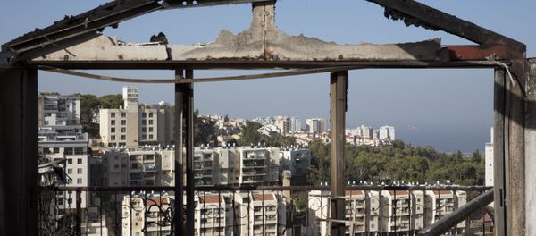 The Mediterranean sea and parts of the city can bee sen through a burned house following wildfires in Haifa, Israel, Friday, Nov. 25, 2016. Israeli firefighters reined in a blaze that had spread across the country's third-largest city and forced tens of thousands of people to flee their homes, but continued to battle more than a dozen other fires around the country for the fourth day in a row. - Sputnik Brasil