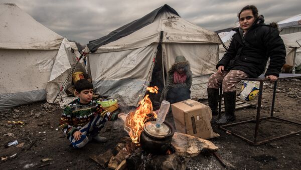 Jovens migrantes se aquecem em torno de um braseiro no campo de migrantes de Grande-Synthe, perto de Dunkirk, em 20 de janeiro de 2016, onde vivem cerca de 2.500 migrantes e refugiados, na sua maioria curdos iraquianos e sírios - Sputnik Brasil