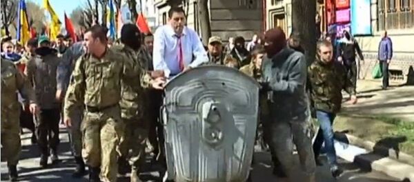 Radicais ucranianos empurrando o chefe do departamento de justiça de Ivano-Frankivsk em uma caçamba de lixo - Sputnik Brasil