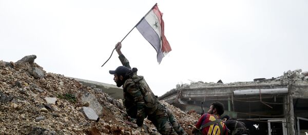 Soldado do exército sírio hasteia a bandeira nacional do seu país durante uma batalha com jihadistas em Aleppo, Síria - Sputnik Brasil