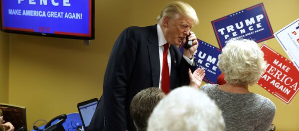 Presidente eleito dos EUA, Donald Trump, ao telefone, em visita a uma empresa de call center de Asheville, Carolina do Norte, durante campanha - Sputnik Brasil