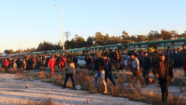 Os evacuados do leste de Aleppo desembarcam dos ônibus após sua chegada à cidade de al-Rashideen, que é mantida pelos insurgentes, na Síria, em 15 de dezembro de 2016. - Sputnik Brasil