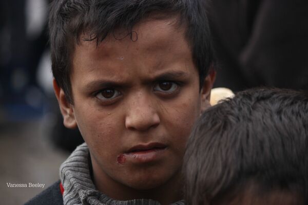 Menino com olhar exausto à espera do recebimento de comida em Aleppo oriental - Sputnik Brasil