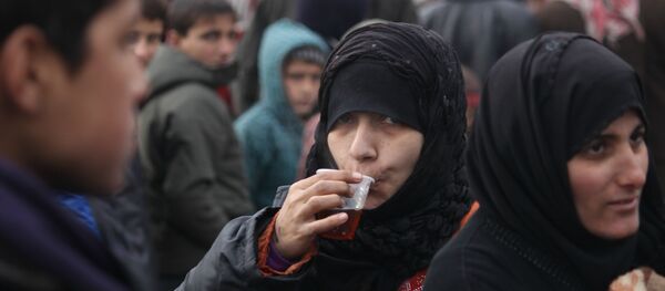 Mulheres e crianças em um ponto de assistência em Aleppo oriental - Sputnik Brasil