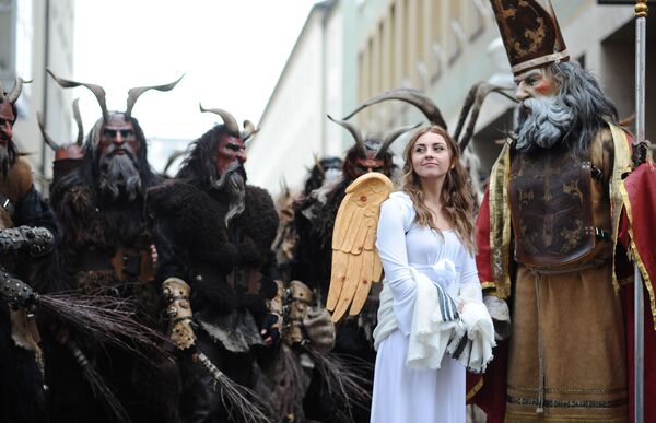 Pessoas vestidas de Krampus, anjo e Papai Noel durante o desfile tradicional de Krampu em Munique, Alemanha - Sputnik Brasil