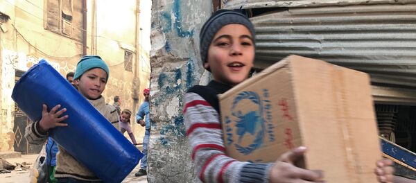 As primeiras crianças a receber a ajuda humanitária russa na parte oriental de Aleppo. - Sputnik Brasil