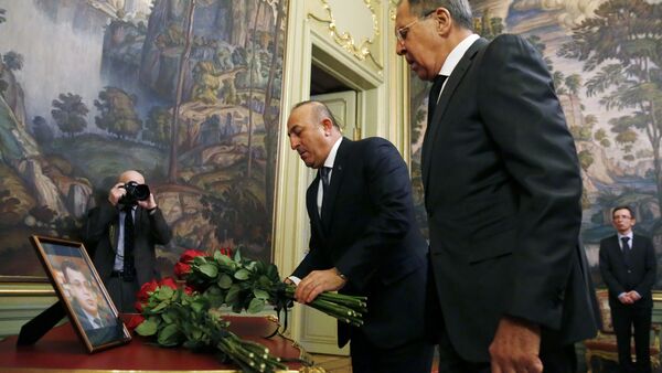 Russian Foreign Minister Sergei Lavrov (R) and his Turkish counterpart Mevlut Cavusoglu lay flowers in front of a photo of Russian ambassador to Turkey, who was killed in Ankara, before their talks in Moscow on December 20, 2016 - Sputnik Brasil