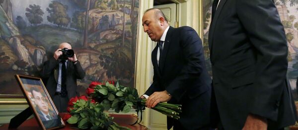 Russian Foreign Minister Sergei Lavrov (R) and his Turkish counterpart Mevlut Cavusoglu lay flowers in front of a photo of Russian ambassador to Turkey, who was killed in Ankara, before their talks in Moscow on December 20, 2016 - Sputnik Brasil