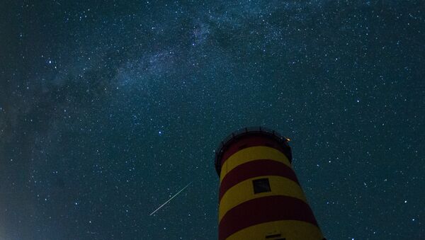 Uma estrela cadente cruza o céu noturno atrás do farol em Pilsum, Alemanha do noroeste - Sputnik Brasil