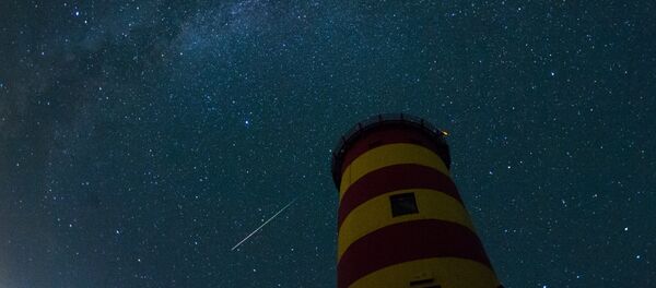 Uma estrela cadente cruza o céu noturno atrás do farol em Pilsum, Alemanha do noroeste - Sputnik Brasil