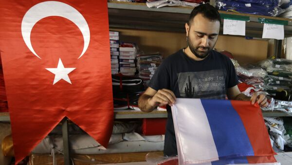 An employee of a flag-making factory folds a Russian flag as a Turkish flag adorns the display at left, in Istanbul, Tuesday, Aug. 9, 2016 - Sputnik Brasil