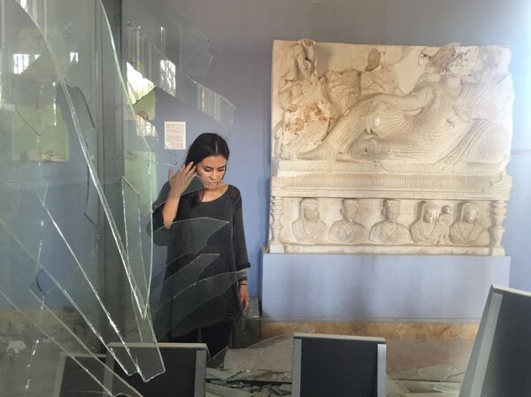 Carla Ortiz junto a uma escultura num prédio destruído, na Síria - Sputnik Brasil