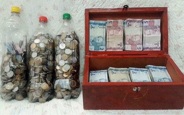 A família guarda as moedas acima de R$ 0,25 em garrafas pet e as notas até R$ 5 em uma caixa e depois levou para o banco - Sputnik Brasil