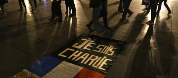 As pessoas passam por uma placa que diz Je suis Charlie (Eu sou Charlie) em homenagem das vítimas do atentado na redação da revista que occoreu em 7 de janeiro de 2015 As pessoas passam por uma placa que diz Je suis Charlie (Eu sou Charlie) em homenagem das vítimas do atentado na redação da revista que occoreu em 7 de janeiro de 2015 - Sputnik Brasil