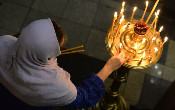 Missas natalinas na noite de 7 de janeiro foram realizadas em igrejas, mosteiros e catedrais de todo o país, de Kaliningrado a Vladivostok. Na imagem, está uma paroquiana da Igreja do Apóstolo Santo André na cidade de Vladivostok, Extremo Oriente da Rússia. - Sputnik Brasil