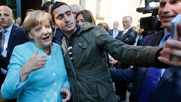 Anas Modamani, natural da capital síria, Damasco, tira um selfie com a chanceler alemã Angela Merkel junto ao centro para refugiados Spandau, em Berlim - Sputnik Brasil