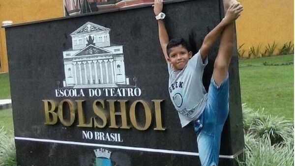 O menino Adrian Barreto junto à placa da Escola Bolshoi Brasil - Sputnik Brasil