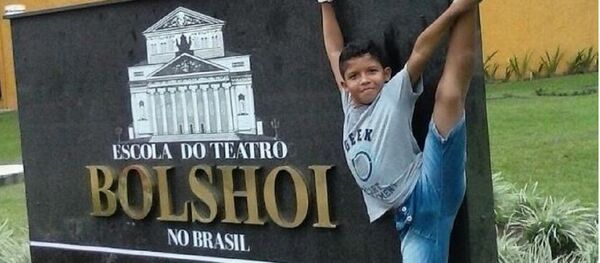 O menino Adrian Barreto junto à placa da Escola Bolshoi Brasil - Sputnik Brasil