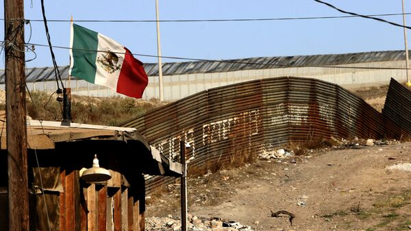 A Mexican flag waves close to the wall which separates Mexico from the United States 24 January 2006, in Tijuana, state of Baja California - Sputnik Brasil