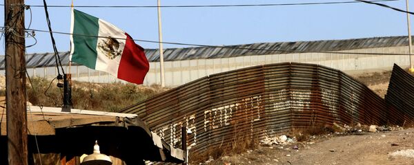 A Mexican flag waves close to the wall which separates Mexico from the United States 24 January 2006, in Tijuana, state of Baja California - Sputnik Brasil