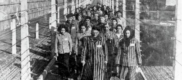 Vítimas do Holocausto marcham por uma das estreitas veredas do campo de concentração de Auschwitz (foto de arquivo) Vítimas do Holocausto marcham por uma das estreitas veredas do campo de concentração de Auschwitz (foto de arquivo) - Sputnik Brasil