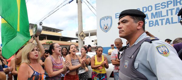 Um agente guarda a entrada da sede da PM em Cachoeira do Itapemirim, ES, enquanto moradores protestam contra a greve policial, que levou ao caos no estado, em 7 de fevereiro de 2017 Um agente guarda a entrada da sede da PM em Cachoeira do Itapemirim, ES, enquanto moradores protestam contra a greve policial, que levou ao caos no estado, em 7 de fevereiro de 2017 - Sputnik Brasil