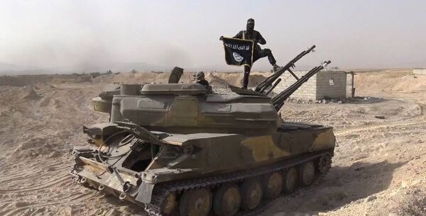 Foto publicada no Facebook em 5 de agosto pela Rased News Network, afiliada do Daesh, mostra um terrorista com bandeira do Daesh sobre um tanque capturado em combate ao exército sírio - Sputnik Brasil