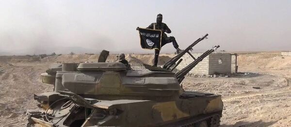 Foto publicada no Facebook em 5 de agosto pela Rased News Network, afiliada do Daesh, mostra um terrorista com bandeira do Daesh sobre um tanque capturado em combate ao exército sírio - Sputnik Brasil