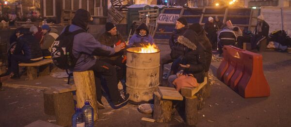 Apoiantes da adesão da Ucrânia à UE se aquecem perto de uma fogueira na Praça da Independência, Kiev, Ucrânia - Sputnik Brasil
