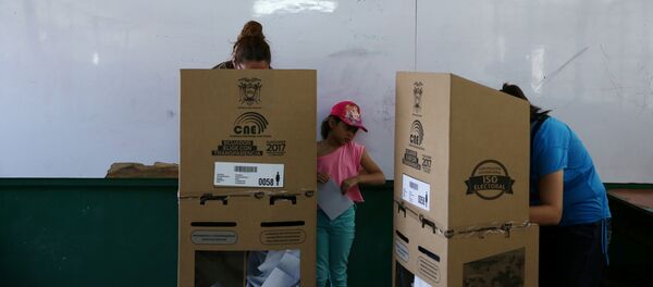 A girl looks on as women cast their votes during the presidential election at a school-turned-polling station in Quito, Ecuador - Sputnik Brasil