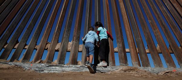 Children play at a newly built section of the U.S.-Mexico border wall at Sunland Park, U.S. opposite the Mexican border city of Ciudad Juarez, Mexico November 18, 2016 - Sputnik Brasil