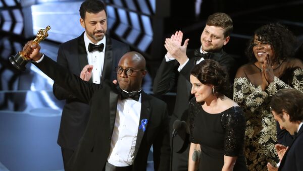 89th Academy Awards - Oscars Awards Show - Hollywood, California, U.S. - 26/02/17 - Writer and Director Barry Jenkins of Moonlight holds up the Best Picture Oscar in front of host Jimmy Kimmel (rear) as he stands with Producer Adele Romanski (R). - Sputnik Brasil