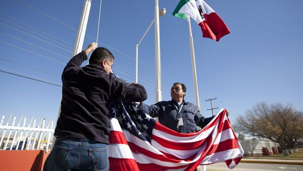 In this Friday, Dec. 27, 2013 photo, workers at one of maquiladoras of the TECMA group prepare to raise the U.S. flag along with the Mexican and TECMA flags in Ciudad Juarez, Mexico - Sputnik Brasil