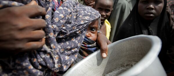 Uma mulher segurando um bebê espera por comida em um campo para desabrigados perto de Mogadíscio, Somália (Arquivo) - Sputnik Brasil