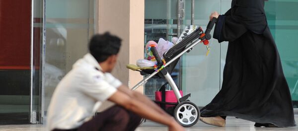 Uma mulher saudita passa por um trabalhador estrangeiro em 7 de novembro de 2013 em Riad. - Sputnik Brasil