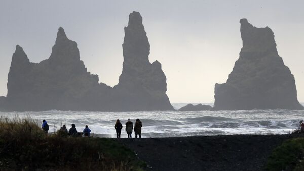 As pessoas andam na praia de areia negra em Vik, Islândia, perto do vulcão Katla - Sputnik Brasil