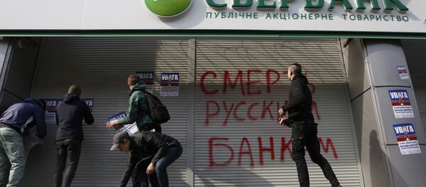 Radicals in front of a Sberbank branch in Kiev, putting up posters which read Attention! This is a bank of an aggressor country. It will be closed. Urgently withdraw your money!, during a protest. Graffiti reads Death to Russian banks. March 10, 2017 Radicals in front of a Sberbank branch in Kiev, putting up posters which read Attention! This is a bank of an aggressor country. It will be closed. Urgently withdraw your money!, during a protest. Graffiti reads Death to Russian banks. March 10, 2017 - Sputnik Brasil