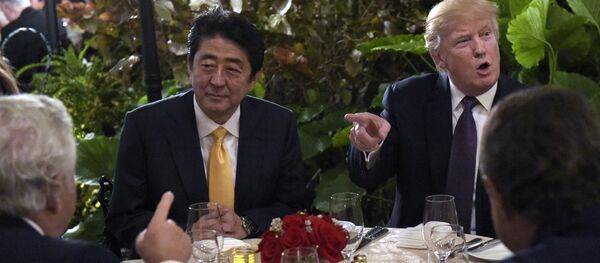President Donald Trump, second from right, sits down to dinner with Japanese Prime Minister Shinzo Abe, second from left, at Mar-a-Lago in Palm Beach, Fla., Friday, Feb. 10, 2017. Robert Kraft, owner of the New England Patriots, is at left. Trump is hosting Abe and his wife for the weekend. - Sputnik Brasil