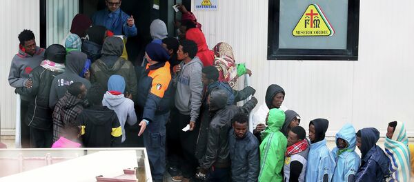 Imigrantes esperam assistência em frente à enfermaria do centro de imigração no sul da Itália, ilha de Lampedusa. - Sputnik Brasil