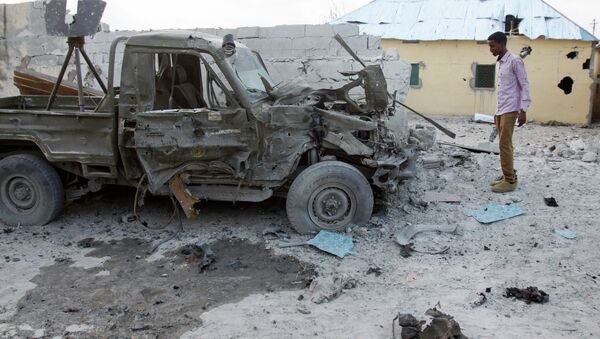 A Somali man stands near the wreckage of a car - Sputnik Brasil