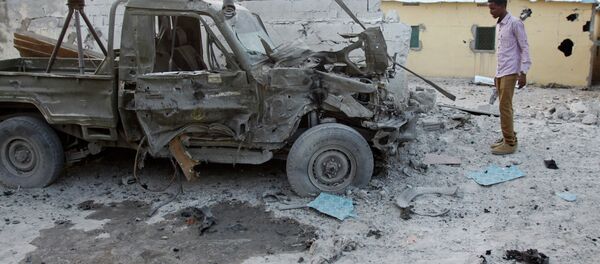 A Somali man stands near the wreckage of a car - Sputnik Brasil