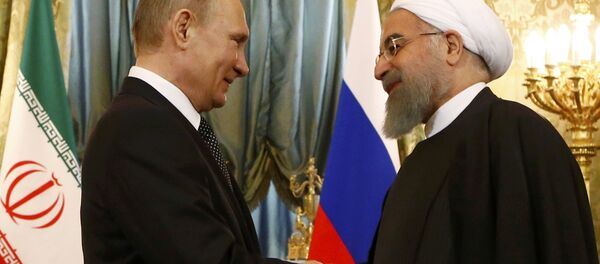 O presidente russo Putin aperta a mão do presidente iraniano Rouhani durante o encontro no Kremlin em Moscou - Sputnik Brasil