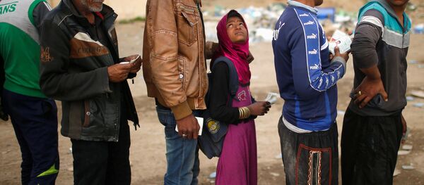 Iraquianos estão na fila para receber recursos alimentícios durante o combate das forças do Iraque com o Daesh, em Mossul ocidental, Iraque, março de 2017 Iraquianos estão na fila para receber recursos alimentícios durante o combate das forças do Iraque com o Daesh, em Mossul ocidental, Iraque, março de 2017 - Sputnik Brasil