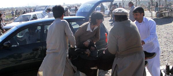 Pakistani men carry an injured blast victim after a bomb explosion at a market in Parachinar, the capital of Kurram tribal district, on December 13, 2015. - Sputnik Brasil