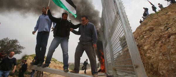 Palestinos tentam remover parte da cerca israelense durante um protesto na Cisjordânia, em 30 de março Palestinos tentam remover parte da cerca israelense durante um protesto na Cisjordânia, em 30 de março - Sputnik Brasil