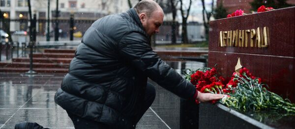 Homem deposita flores na tumba da cidade de Leningrado, no jardim das cidades heroicas da Segunda Guerra Mundial de Moscou, em homenagem aos mortos durante a explosão no metrô de São Petersburgo - Sputnik Brasil