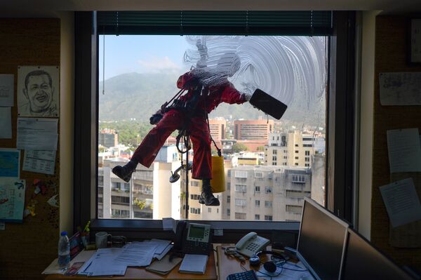 Lavador de janelas em um dos prédios da capital venezuelana, Caracas - Sputnik Brasil