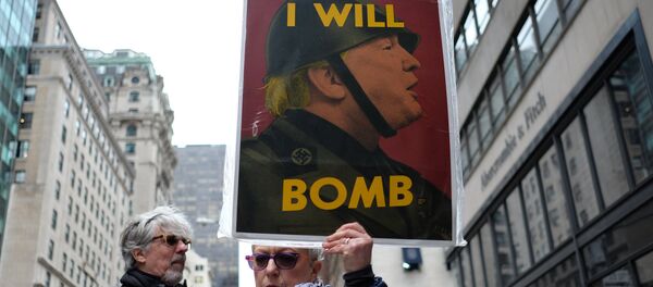 Manifestante pacifista mostra um cartaz contra o bombardeio no território sírio ordenado por Donald Trump, em Nova York, em 7 de abril de 2017 - Sputnik Brasil