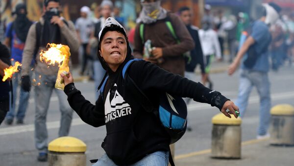 A demonstrator throws a molotov cocktail while clashing with riot police during a rally against Venezuela's President Nicolas Maduro's government in Caracas - Sputnik Brasil