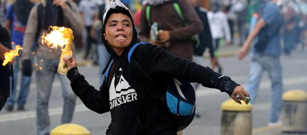 Um manifestante atira um coquetel Molotov, durante os protestos contra o governo em Caracas, na Venezuela, em 10 de abril de 2017 - Sputnik Brasil